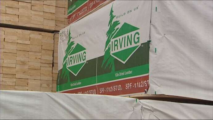 A sign with a tree symbol and the Irving logo next to a pile of wood
