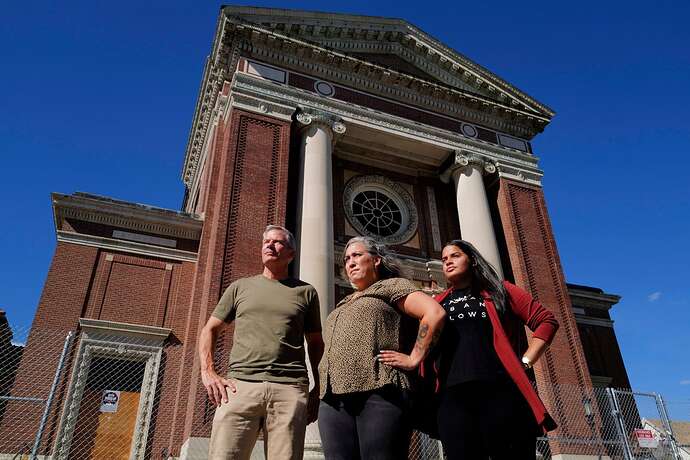 Harry Smith (left), Vanessa Snow (center), and Cisnell Baez (right) stood in front of the Blessed Sacrament Church in Jamaica Plain’s Latin Square on Sept. 1, 2022. The group of local organizers contributed to an effort to transform the church into a more than 50-unit affordable housing and community space.