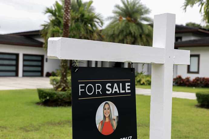 A For Sale sign sits in front of a home.