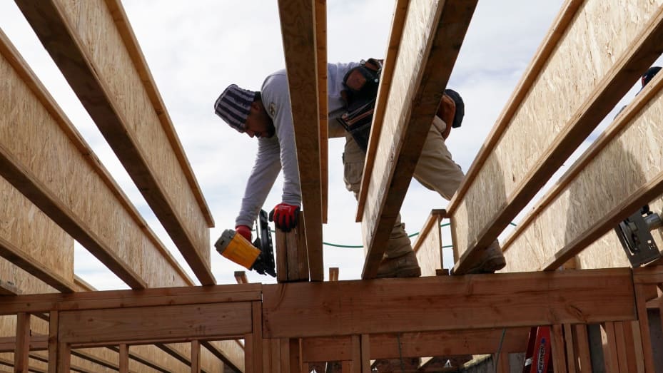 A worker drills plywood on a single family home under construction in Lehi, Utah, on Friday, Jan. 7, 2022.