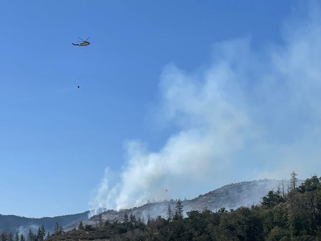 A helicopter drops water on the Upper Applegate Fire.