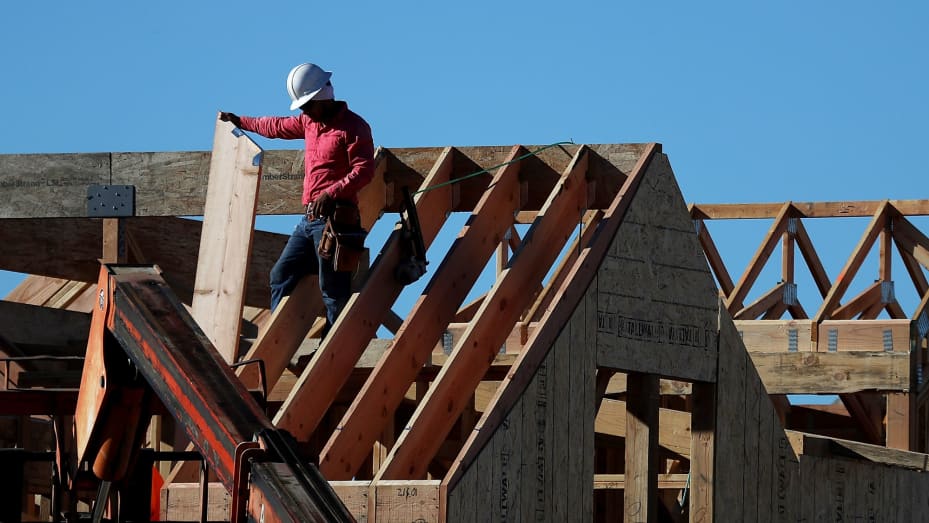 A worker stands on the roof of a home under construction at a new housing development in San Rafael, California.